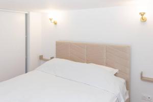 a bedroom with a white bed with a headboard at Appartement T2 - Roubaix Centre in Roubaix