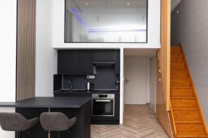 a kitchen with a black counter and a staircase at Appartement T2 - Roubaix Centre in Roubaix