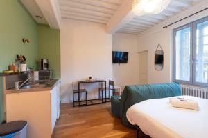 um quarto com uma cama e uma cozinha com um lavatório em Cabana & La Place de l'Abbaye - Centre-Ville, Jardin em Cluny