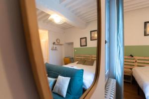 uma sala de estar com um sofá azul e uma cama em Cabana & La Place de l'Abbaye - Centre-Ville, Jardin em Cluny