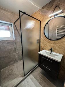 La salle de bains est pourvue d'une douche, d'un lavabo et d'un miroir. dans l'établissement BART APARTMENTS Veľká Lomnica, à Veľká Lomnica