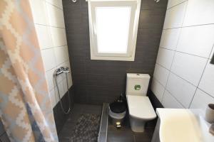 a small bathroom with a toilet and a window at Roof Central Suite in Kavala +33 photos