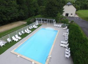 an overhead view of a swimming pool with lounge chairs at La Grange du Devezou in Saint-Jacques-des-Blats