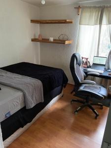 a bedroom with a bed and a desk with a laptop at Habitación en departamento muy céntrico in Mexico City