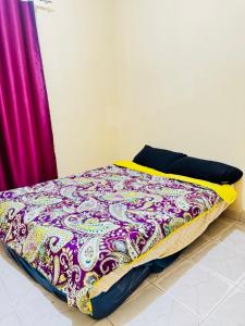 a bed with a colorful blanket on top of it at Binga villa in Kisoro