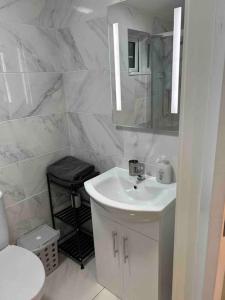 een witte badkamer met een wastafel en een spiegel bij Atlantic Sea View in Tralee