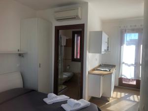 a bedroom with a bed and a bathroom with a sink at Aurasol Alghero in Alghero