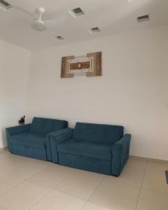 a blue couch in a room with a painting on the wall at Cantinho da Lili in Ubatuba