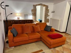 een oranje bank met kussens in de woonkamer bij Il Rustico in Sansepolcro
