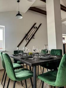 une salle à manger avec une table et des chaises vertes dans l'établissement BART APARTMENTS Veľká Lomnica, à Veľká Lomnica