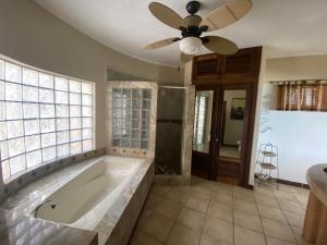 a large bathroom with a tub and a ceiling fan at Alojamientos Alexa in Sayulita