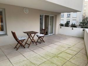 un patio con 2 sillas y una mesa en el balcón en La demeure des Rois - Parking - Metro - Stade de France, en Saint-Denis