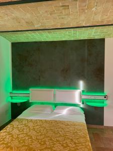 a bedroom with a bed with a green headboard at Regis Resort & Wellness in Turrivalignani
