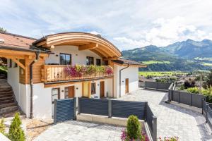 a house with a balcony with a view of mountains at Villa Oberbichl in Piesendorf