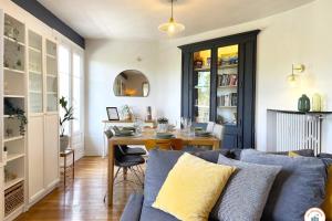 een woonkamer met een bank en een tafel bij Le Penthouse - Magnifique Vue - Standing in Caen