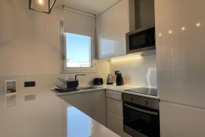 cocina blanca con fregadero y microondas en The Black Swan - Hypercentre - Tout confort en Caen