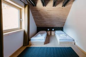 2 Betten in einem kleinen Zimmer mit Fenster in der Unterkunft Lesná chata Liptov in Ružomberok