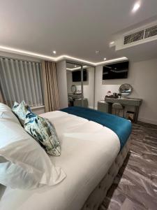 a bedroom with a large white bed with a desk at Philharmonic Hotel in Liverpool