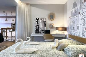2 cigni sono seduti su un letto in una camera da letto di Entre Ciel et Terre - Vue Magnifique - Loft a Caen