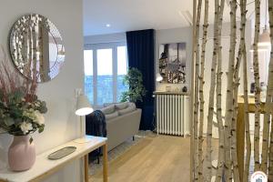 a living room with a couch and a table at Entre Ciel et Terre - Vue Magnifique - Loft in Caen