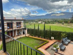 a view from a balcony of a house with a garden at Hotel Pliosaurio Campestre in Villa de Leyva