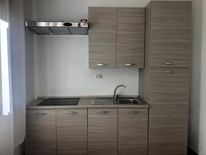 a kitchen with wooden cabinets and a sink at Aurasol Alghero in Alghero +91 photos