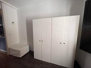un armadio bianco con sgabello in una stanza di Casa vacanze appartamento Ibiza città a Ibiza Città