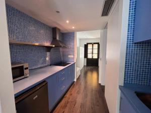 a kitchen with blue tiles on the walls and a counter at Casa vacanze appartamento Ibiza città in Ibiza Town