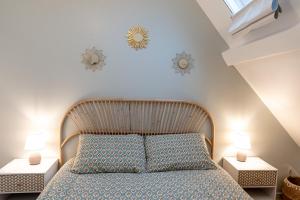een slaapkamer met een groot bed met 2 nachtkastjes bij Le petit Giennois in Gien