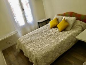 a bedroom with a bed with two yellow pillows at Eco Champs Elysees in Paris