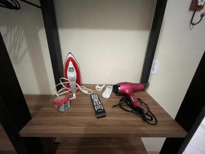 ein Tisch mit einem Spiegel und einer roten Lampe und einer Fernbedienung in der Unterkunft Casa aconchegante com ar condicionado para família em condomínio in Caraguatatuba