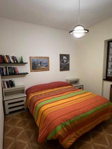 a bedroom with a bed with a colorful blanket at Casa del Sole in Castione della Presolana