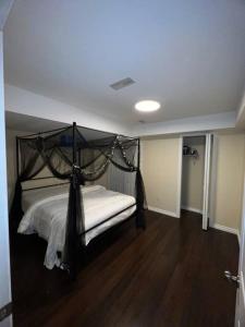 a bedroom with a bed with a black canopy at 2 bedroom cozy entire ground floor in Vaughan
