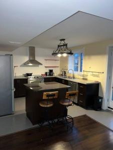 a kitchen with a island with three bar stools at 2 bedroom cozy entire ground floor in Vaughan