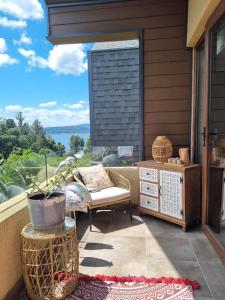 a patio with a table and a chair and a window at Costanera Playa Villarrica in Villarrica