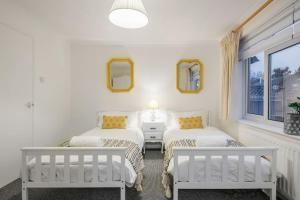 Duas camas brancas num quarto com uma janela em Newly renovated 5 Bed - Call 4 LONG STAY discount em Winkfield