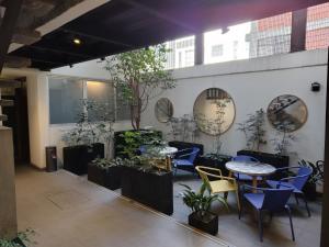 a patio with tables and chairs and potted plants at ZAMORA By Mr W in Mexico City