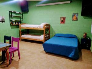 - une chambre avec 2 lits superposés et une table dans l'établissement El Escarabajo Azul loft & Arte, à Villa Carlos Paz