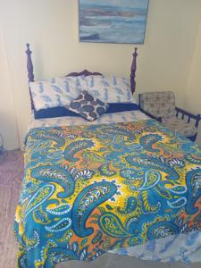 a bed with a colorful blanket and pillows on it at PeachBloom Tereace Inn in DʼArbeau