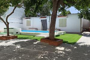 a yard with a swimming pool and two trees at El Cortijo de Palma in Villarejo de Salvanés