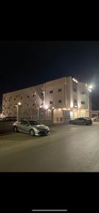 deux voitures garées devant un bâtiment la nuit dans l'établissement فندق نوفا بارك, à Sharurah
