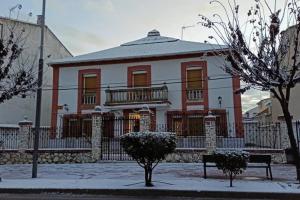 a white and red house with a balcony at El Cortijo de Palma in Villarejo de Salvanés