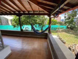 a porch with a hammock and a view of a pool at Casa Finca San Nicolas in Sabaneta