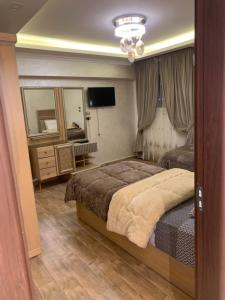 una camera con letto, cassettiera e televisore di المهندسين a Il Cairo