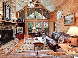 a living room with a couch and a fireplace at Providence Cabin in Townsend