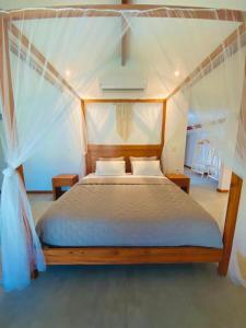 a bedroom with a canopy bed with two pillows at Dream Beach Cumbuco Superior Oceanfront Apartments in Cumbuco