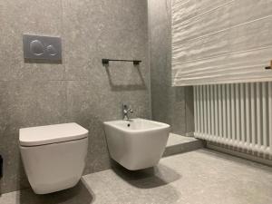 ein Badezimmer mit einer weißen Toilette und einem Waschbecken in der Unterkunft VillaFiera, Studio near Fiera Milano at Metro stop in Pero + 11 Fotos