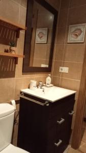 een badkamer met een wastafel, een toilet en een spiegel bij EnFOZ PLAYAS ÚNICAS Y DIVINAS! in Foz