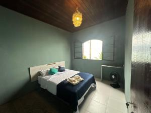 um quarto com uma cama com lençóis azuis e uma janela em LaVille - Suítes em São Sebastião