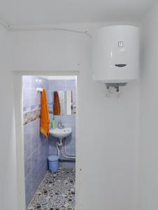 ein Bad mit einem Waschbecken und einem Spiegel in der Unterkunft Dar ettawfik in Tataouine